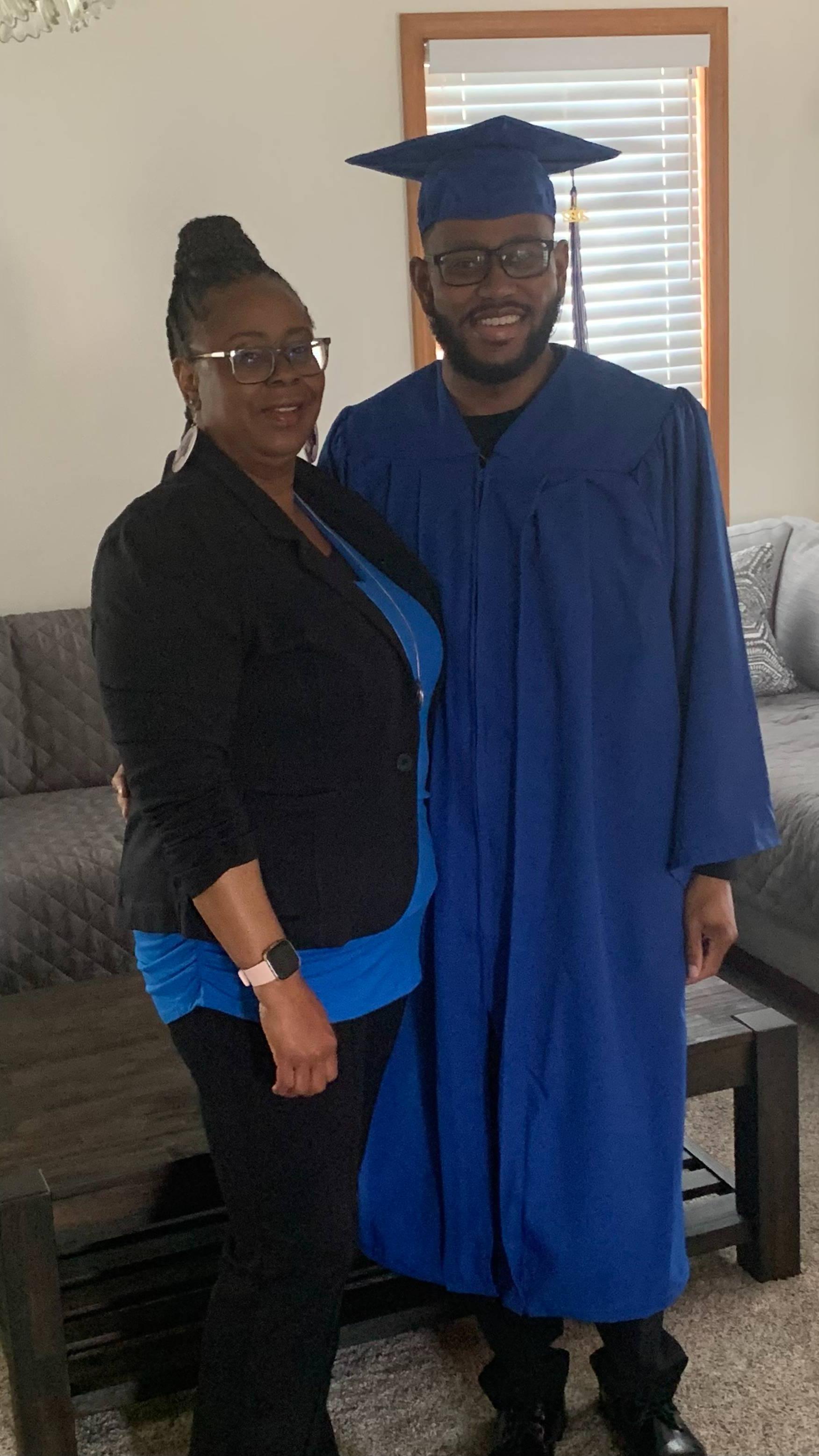 Tina Lee standing and smiling with her son, 丹尼尔, in his cap and gown